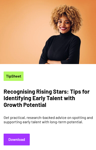 A person with curly hair wearing a plain turtleneck