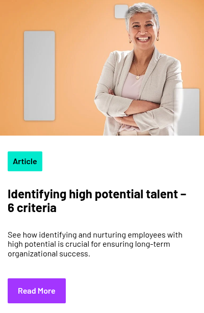 Person standing against an orange background, smiling with arms crossed, dressed in a light-colored blazer and top